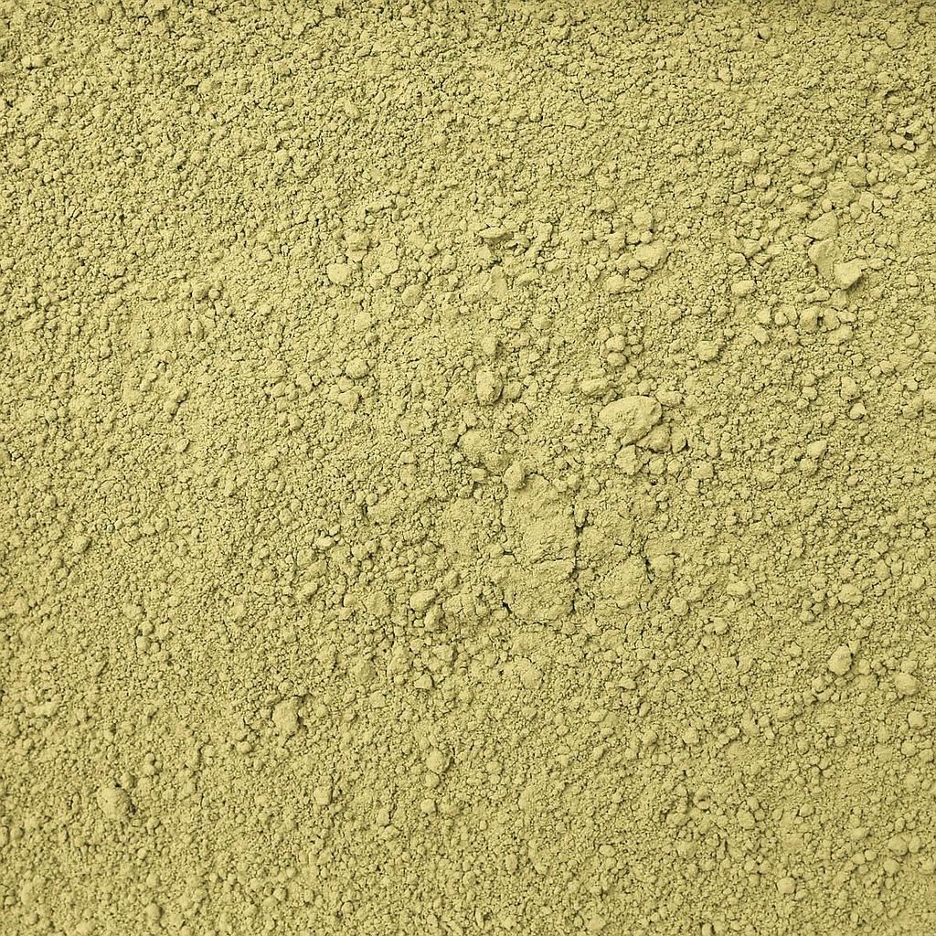 Fine green matcha tea powder from Tea Spot in a glass jar, with a scoop on a wooden surface.