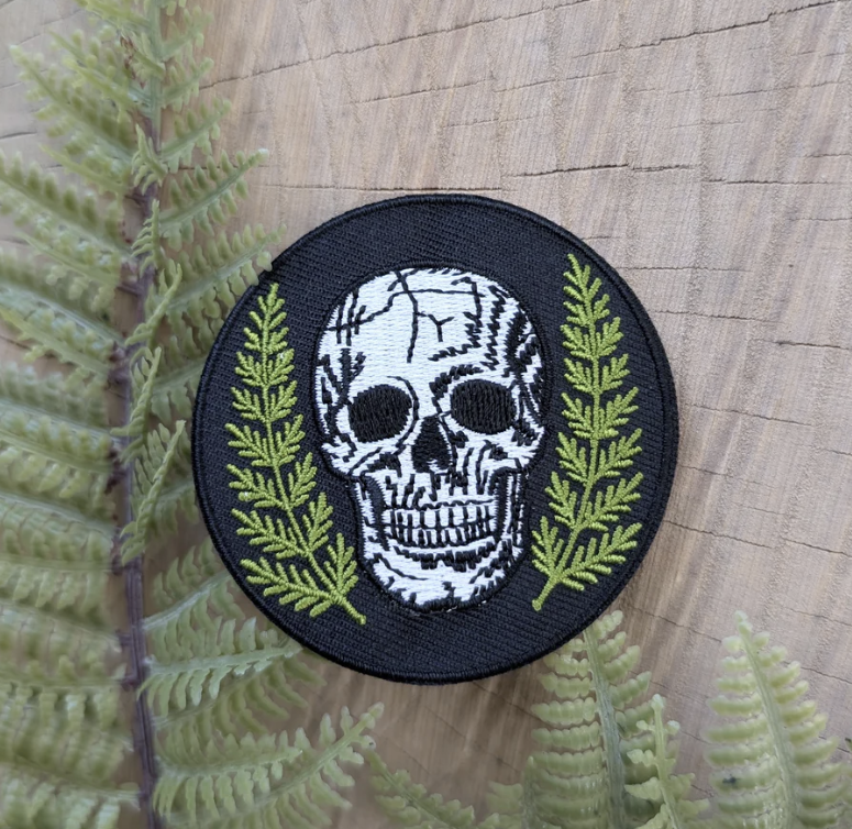 Close-up of ilikesara Patches showing colorful, embroidered fabric patches with intricate designs and branding details.