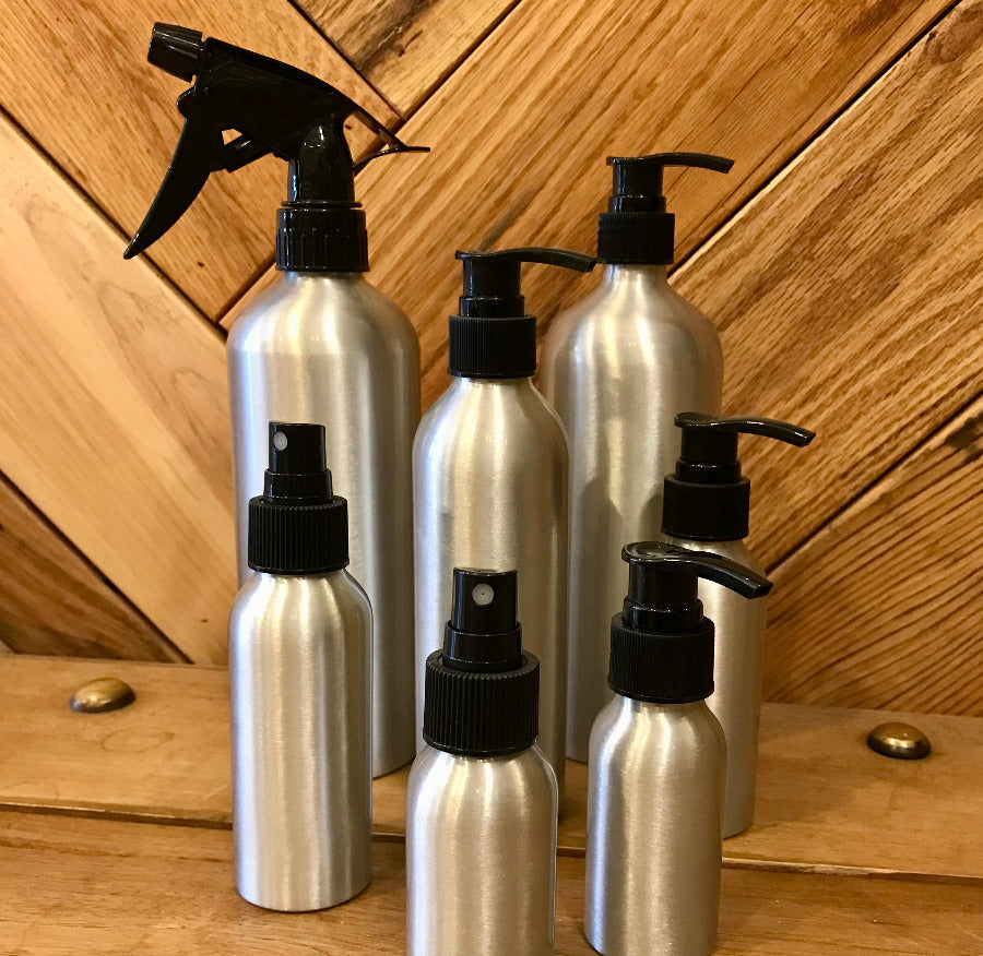 Aluminum bottles with lotion, soap, and fine mist spray pumps from OTB Refills, showcasing sleek reusable containers with pump heads.