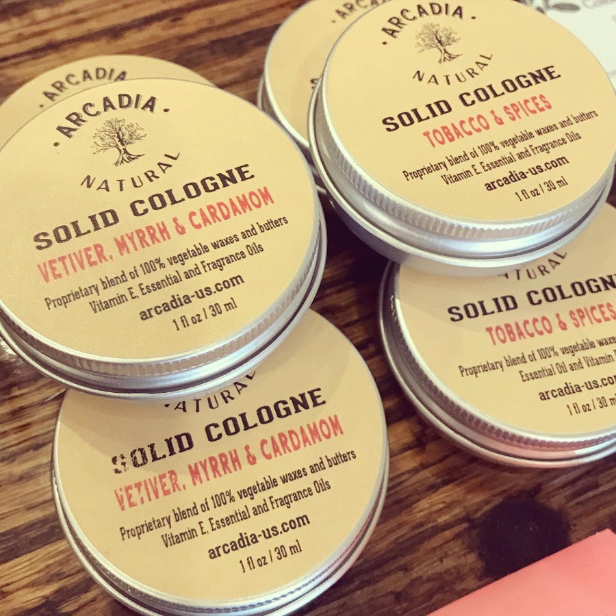 Natural solid perfume by Arcadia Naturals, featuring a sleek container and aromatic scent in a close-up image.