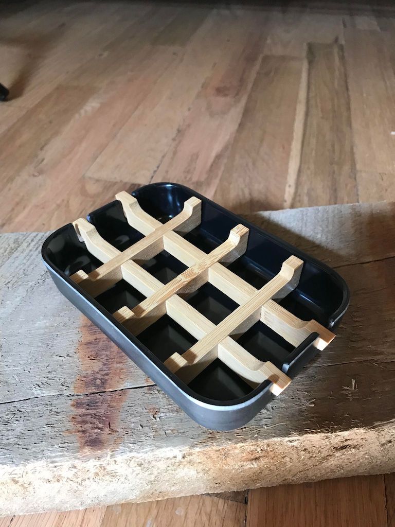 Black bamboo fiber soap dish with a sleek base, designed to hold soap bars in a modern bathroom setting.