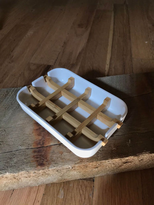 White bamboo fiber soap dish with a sleek base, designed for holding bars of soap in a modern bathroom.
