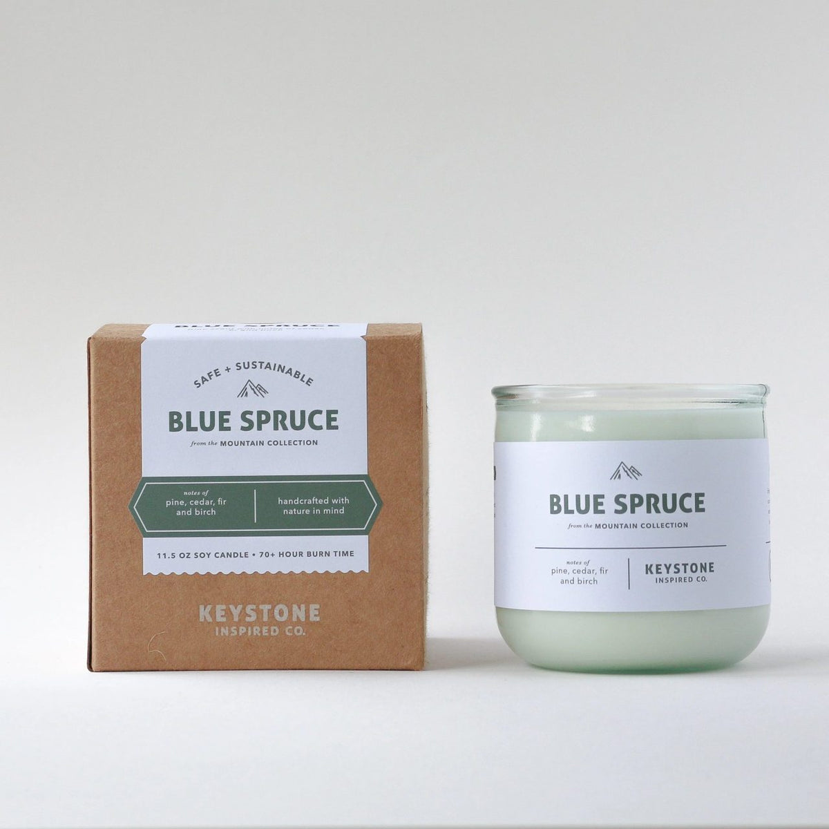 Blue spruce scented soy candle in a 11.5 oz glass jar by Keystone Inspired, with a cozy, natural forest-inspired design.