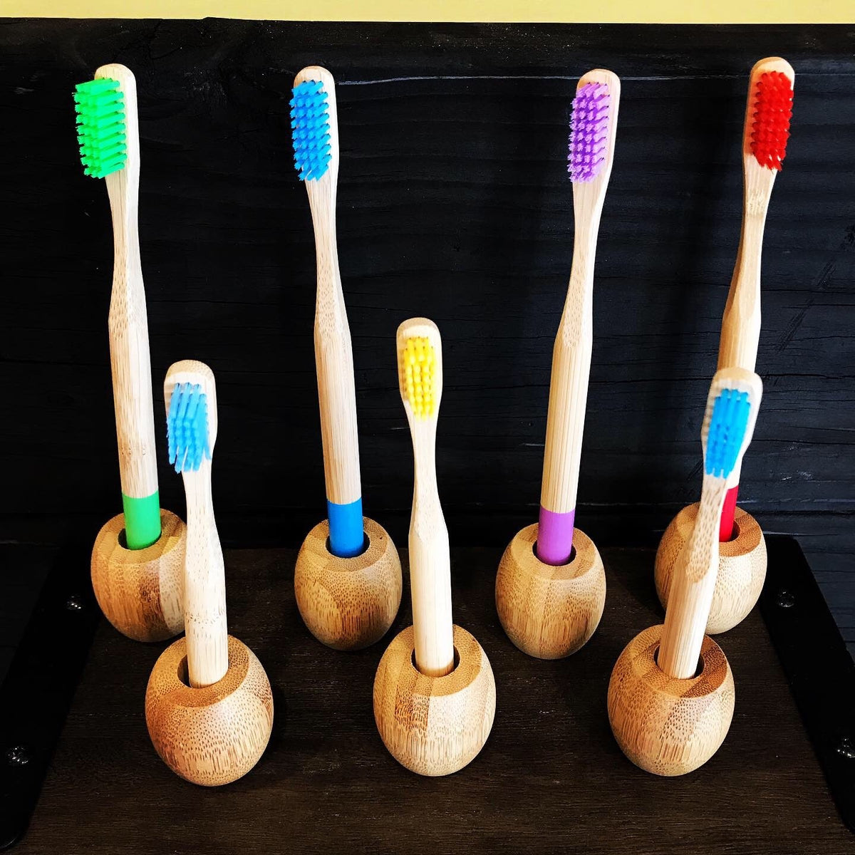 Set of colorful bamboo toothbrushes by OTB Refills, showcasing eco-friendly wooden handles and soft bristle heads.