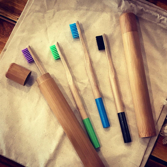 Colorful bamboo toothbrushes from OTB Refills with soft bristles, displayed in a natural setting.