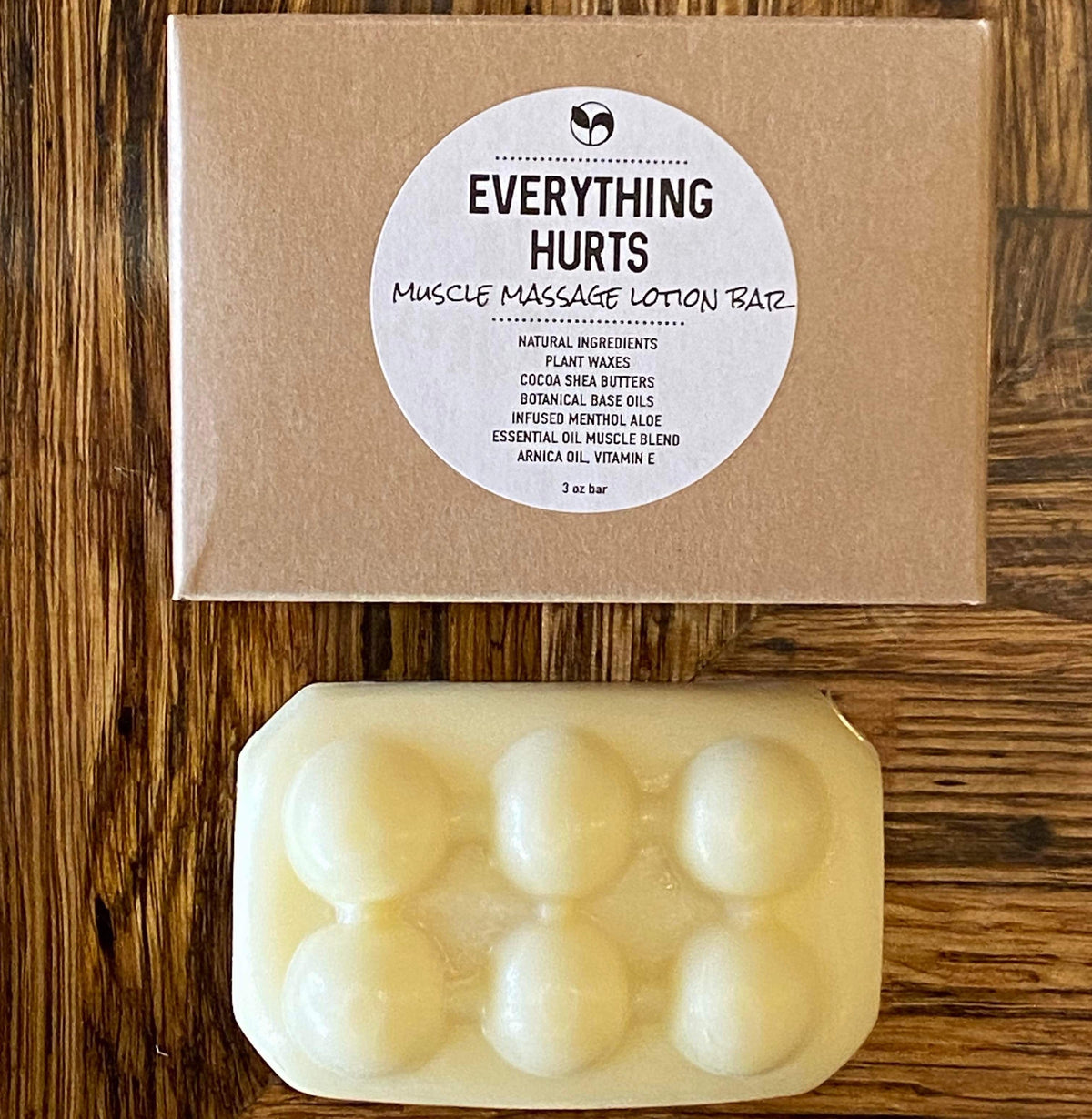 ScentCerae Everything Hurts Muscle Massage Lotion Bar showing a solid lotion bar in a natural setting
