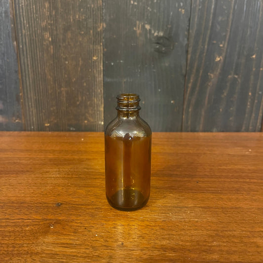 OTB Refills Amber Glass Boston Bottle, 2 oz, with a clear glass body and black screw cap for essential oil or perfume storage.