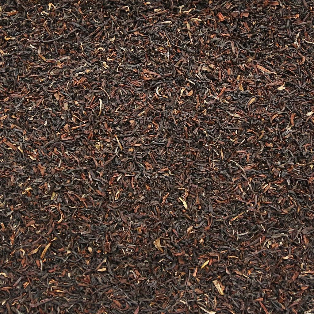 Organic Darjeeling Tea by Essential Organics in a glass teapot with loose tea leaves and brewed tea ready to serve.