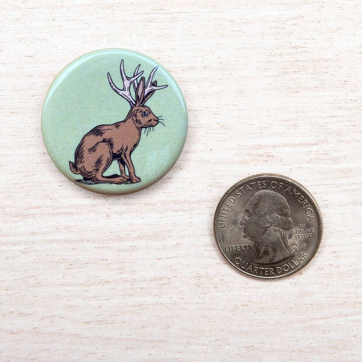 Counter Couture button on a fabric, showcasing its detailed design and vibrant color, ideal for clothing or craft projects.