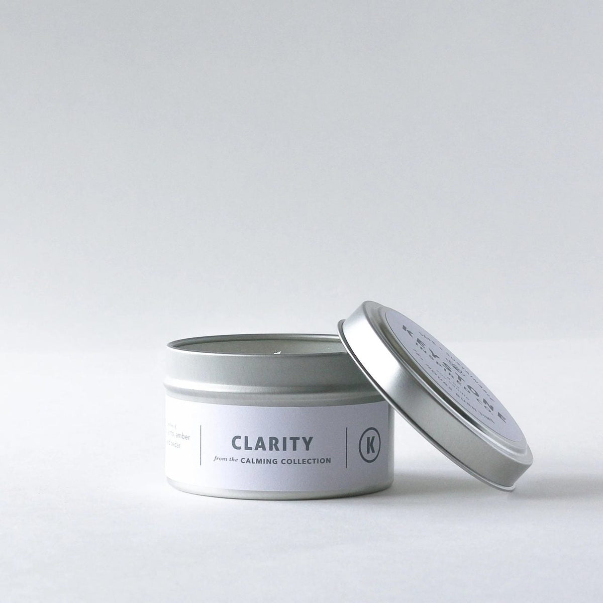 Keystone Inspired 4 oz soy candles in travel tin, showing a cozy candle with a lit wick and rustic label for ambient lighting.