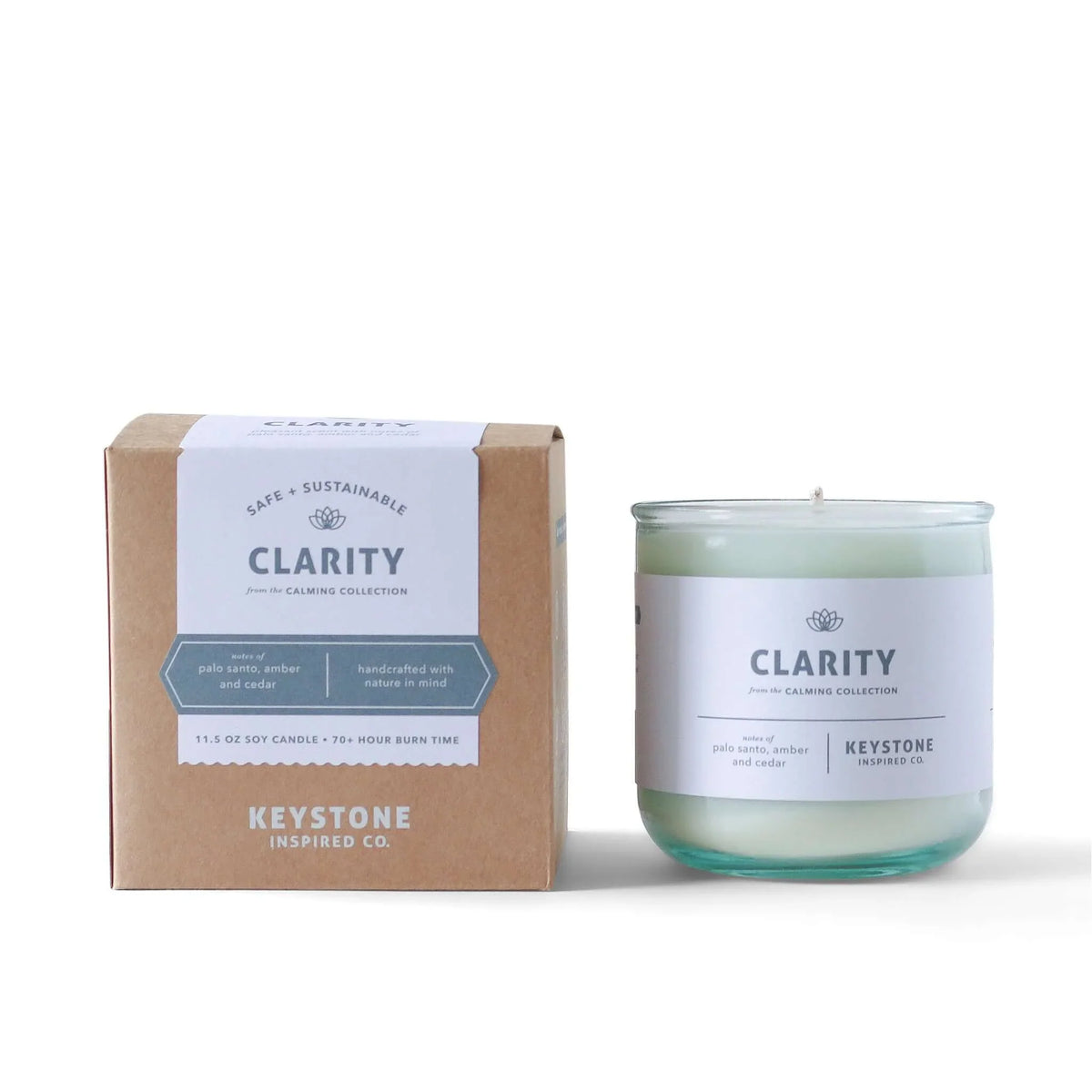11.5 oz Keystone Inspired soy candle in a clear glass jar, with a lit wick and soft glow, perfect for home decor and ambiance.