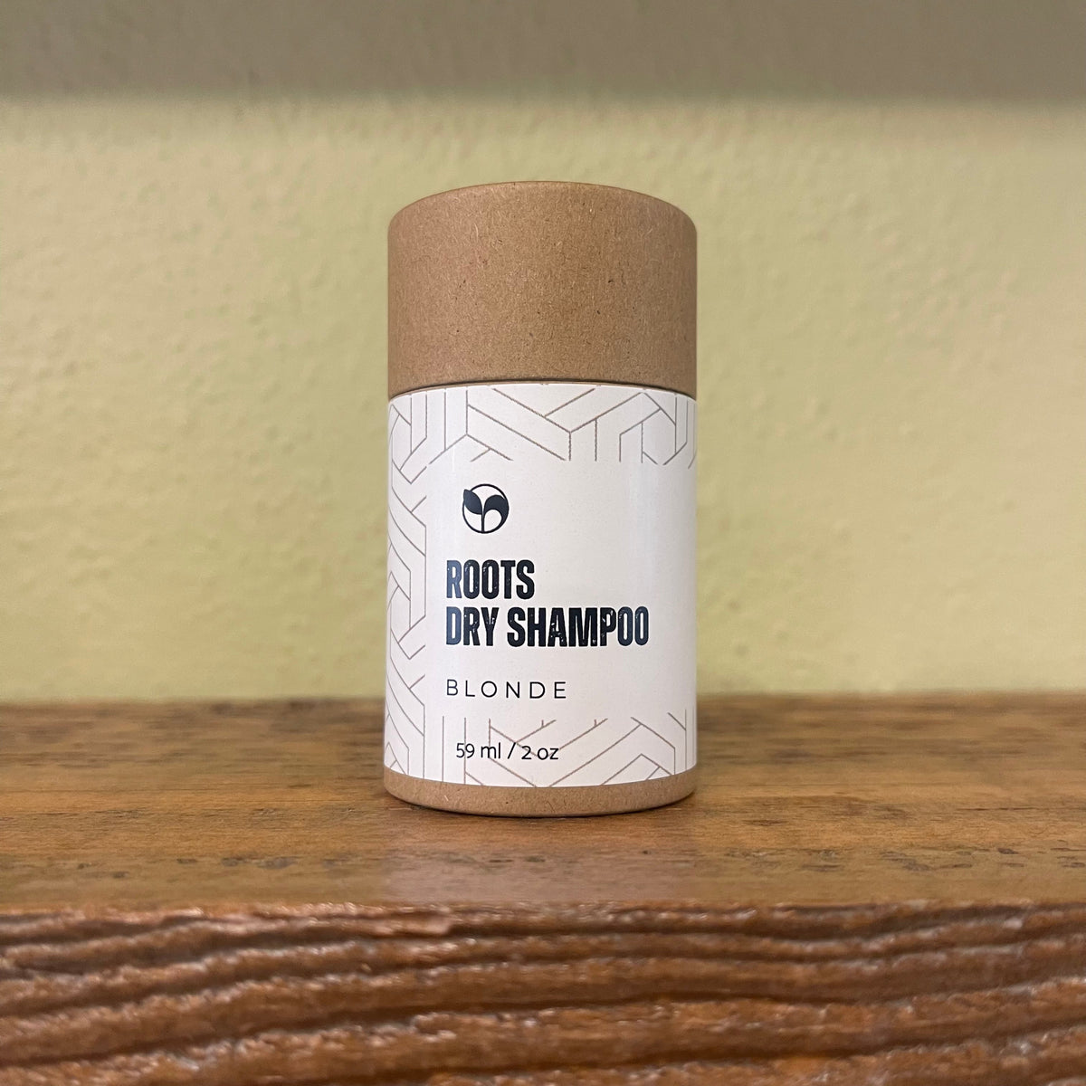 Natural Roots Dry Shampoo by ScentCerae in 2oz shaker, showing the powder-filled container with a black cap.