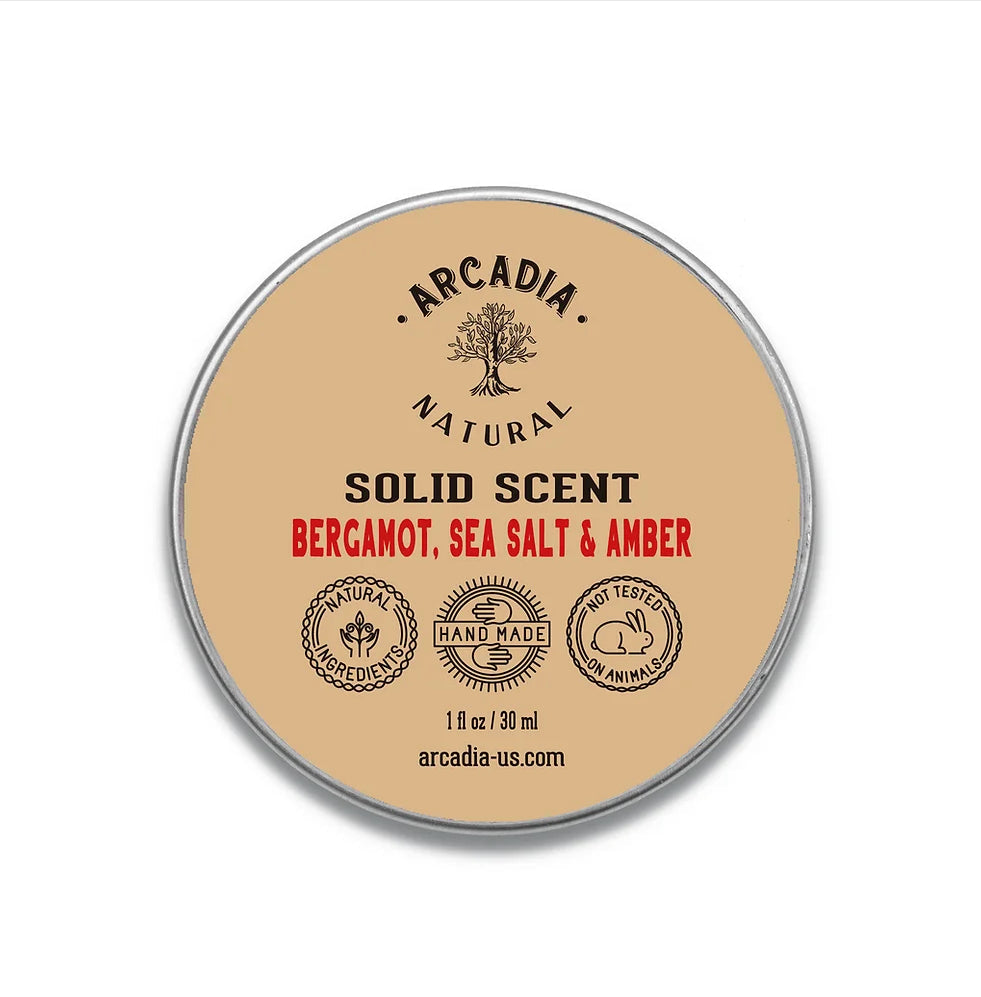 Natural solid perfume by Arcadia Naturals, showing a compact, elegant container with a smooth, natural-colored solid fragrance.