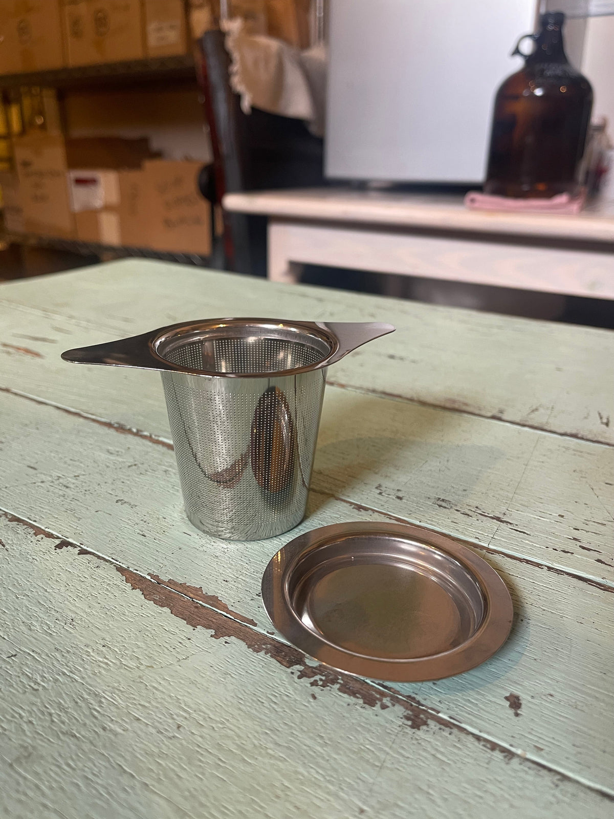 OTB Refills tea strainer and infuser inside a cup for loose leaf tea brewing, with stainless steel mesh and ergonomic handle.