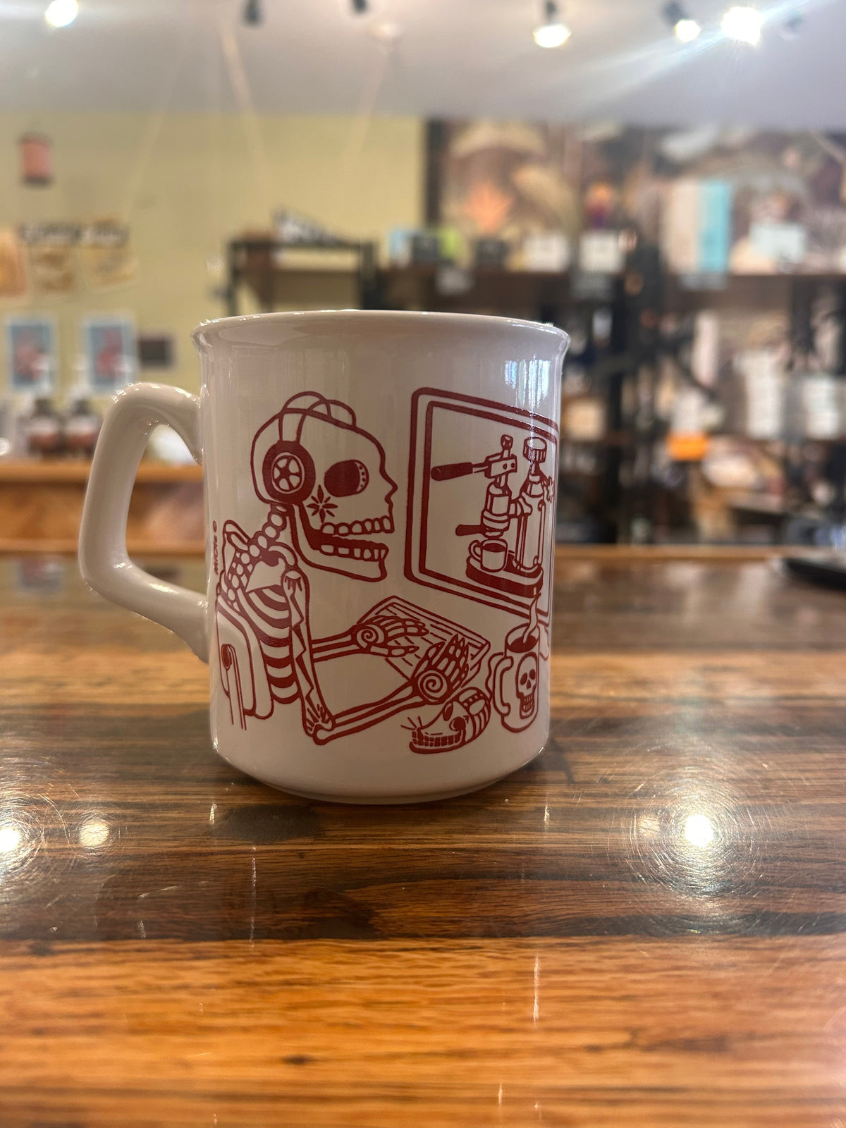 MiOle coffee mugs featuring a white ceramic design with black and red accents, shown on a wooden surface.