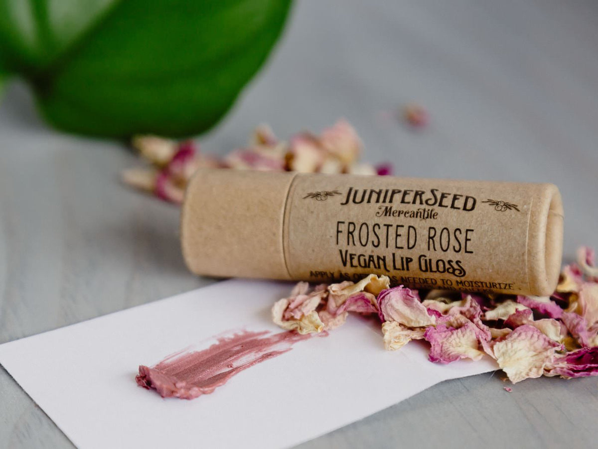 Juniperseed Mercantile Lip Balms displayed in natural packaging with a close-up of the balm tubes and label details.