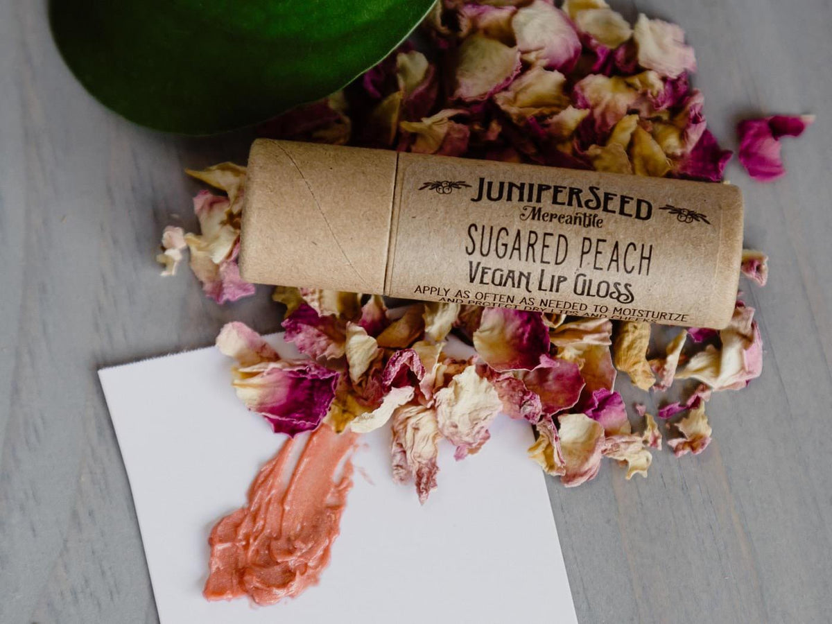 Juniperseed Mercantile Lip Balms in assorted flavors with natural packaging, displayed in a close-up shot.