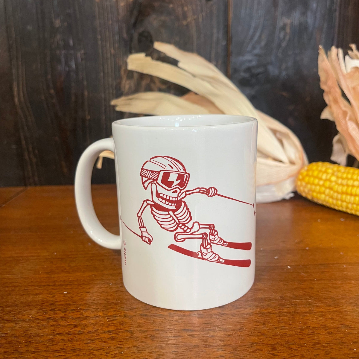 MiOle coffee mug with a white ceramic body and a curved handle, featuring a minimalistic design on a wooden table.