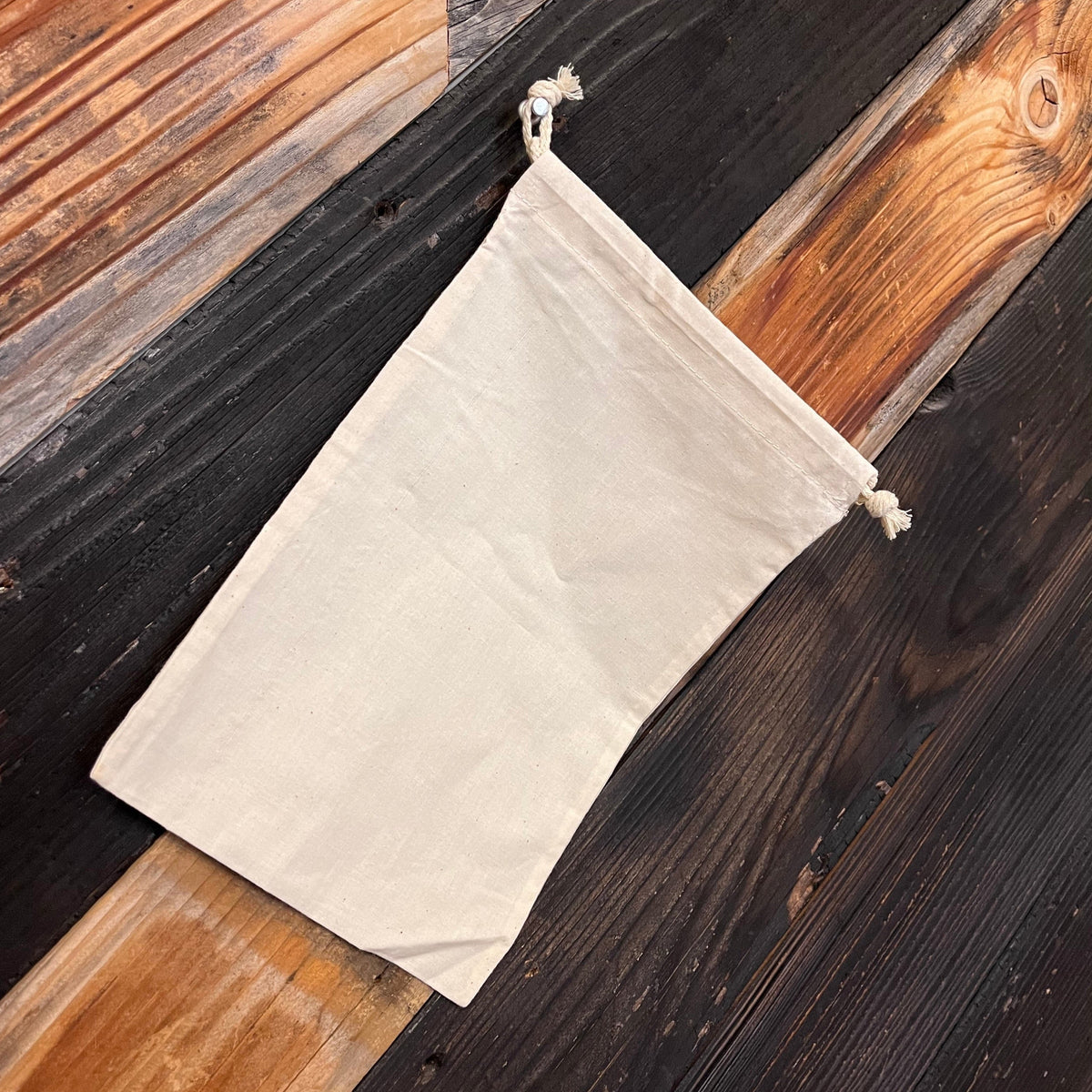 Cotton drawstring bag by OTB Refills in various sizes, showing a natural fabric texture and adjustable closure.