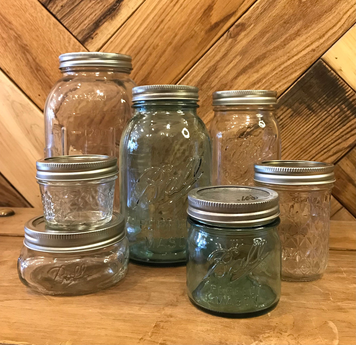 Clear glass Ball Mason jars with metal lids, ideal for storage or canning, showcasing their classic design and sturdy build.