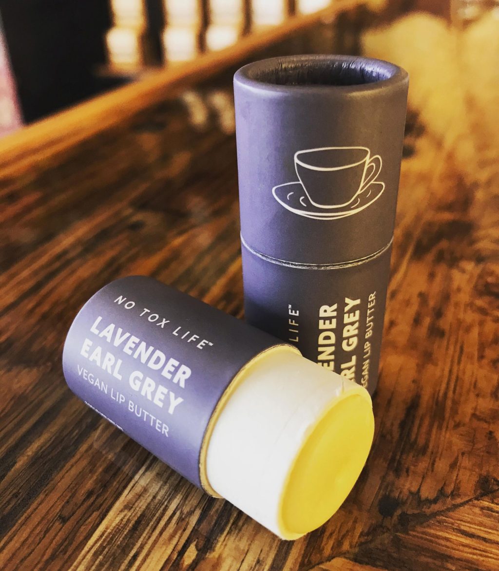 Lavender Earl Grey Lip Butter Balm by No Tox Life showing the smooth, natural balm in a small container with a lid.