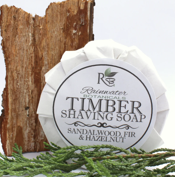 Rainwater Botanicals shave soap in a wooden bowl, showcasing a creamy lather and natural ingredients for a smooth shave.