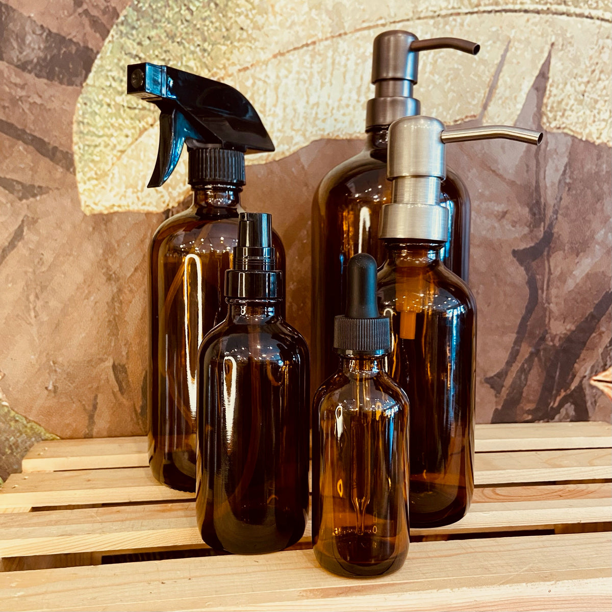 Amber glass Boston bottles in 32, 16, and 8 oz sizes from Premium Vials, shown with their classic rounded shape and amber color.
