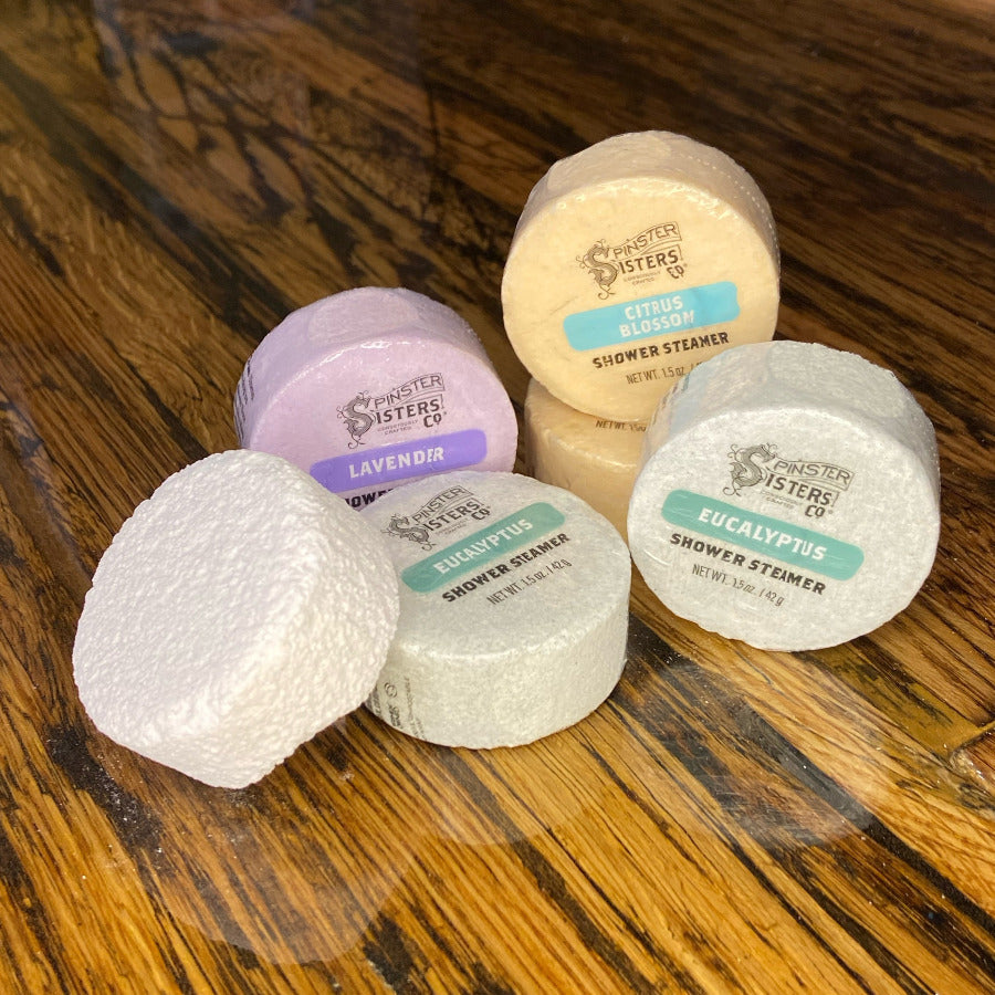 Set of Spinster Sisters shower steamers with aromatic herbs and essential oils, designed to create a relaxing bathing experience.