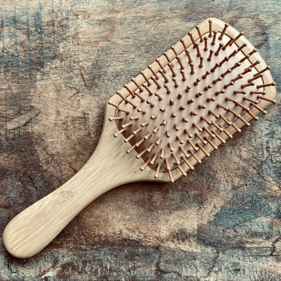 OTB Refills bamboo rectangular massaging hair brush with smooth wooden bristles for gentle scalp massage and detangling.