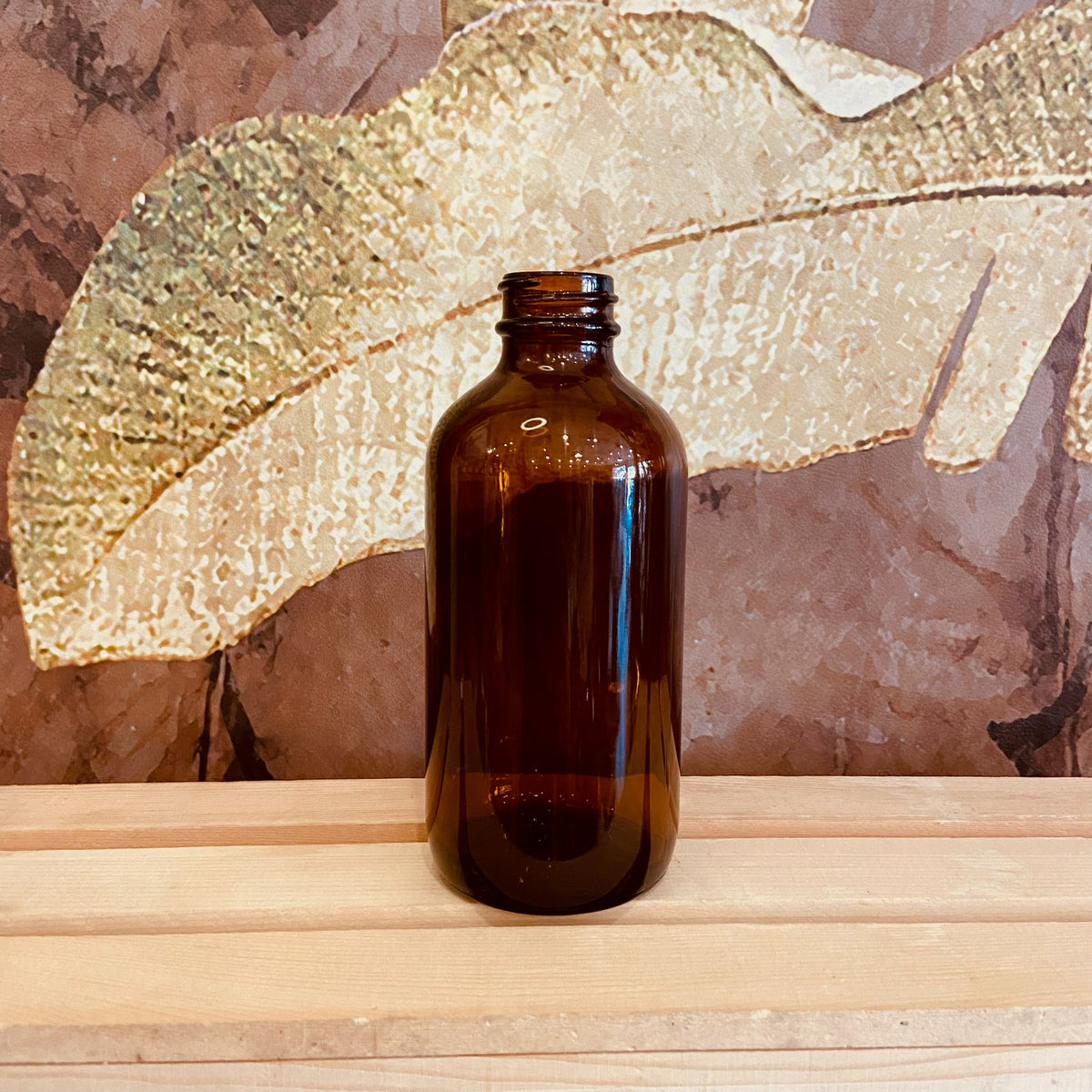 Amber glass Boston bottles in 32, 16, and 8 oz sizes from Premium Vials, showing clear, durable glass bottles with metal caps.